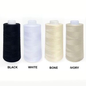 May include: Four spools of thread in black, white, bone, and ivory colors. The spools are arranged from left to right in the order of the colors listed.