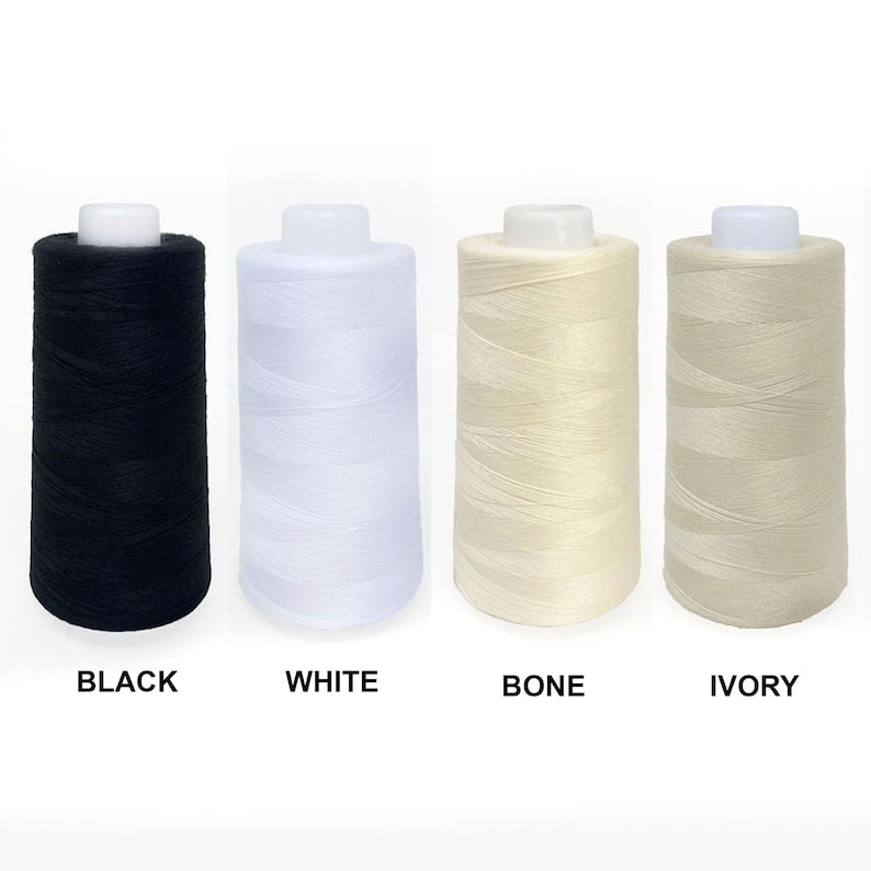 May include: Four spools of thread in black, white, bone, and ivory colors. The spools are arranged from left to right in the order of the colors listed.