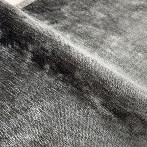 Puede incluir: Primer plano de una alfombra suave gris y negra con un brillo sutil. La alfombra tiene un aspecto texturizado y tejido.