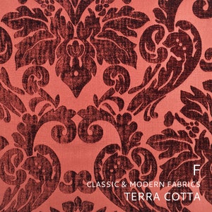 Puede incluir: Primer plano de una tela de color terracota con un patr&oacute;n damasco marr&oacute;n oscuro. La tela es texturizada y tiene un brillo sutil. El texto "CLASSIC & MODERN FABRICS TERRA COTTA" est&aacute; impreso en la parte inferior de la imagen.