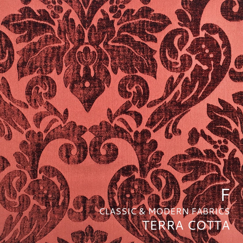 Puede incluir: Primer plano de una tela de color terracota con un patr&oacute;n damasco marr&oacute;n oscuro. La tela es texturizada y tiene un brillo sutil. El texto "CLASSIC & MODERN FABRICS TERRA COTTA" est&aacute; impreso en la parte inferior de la imagen.