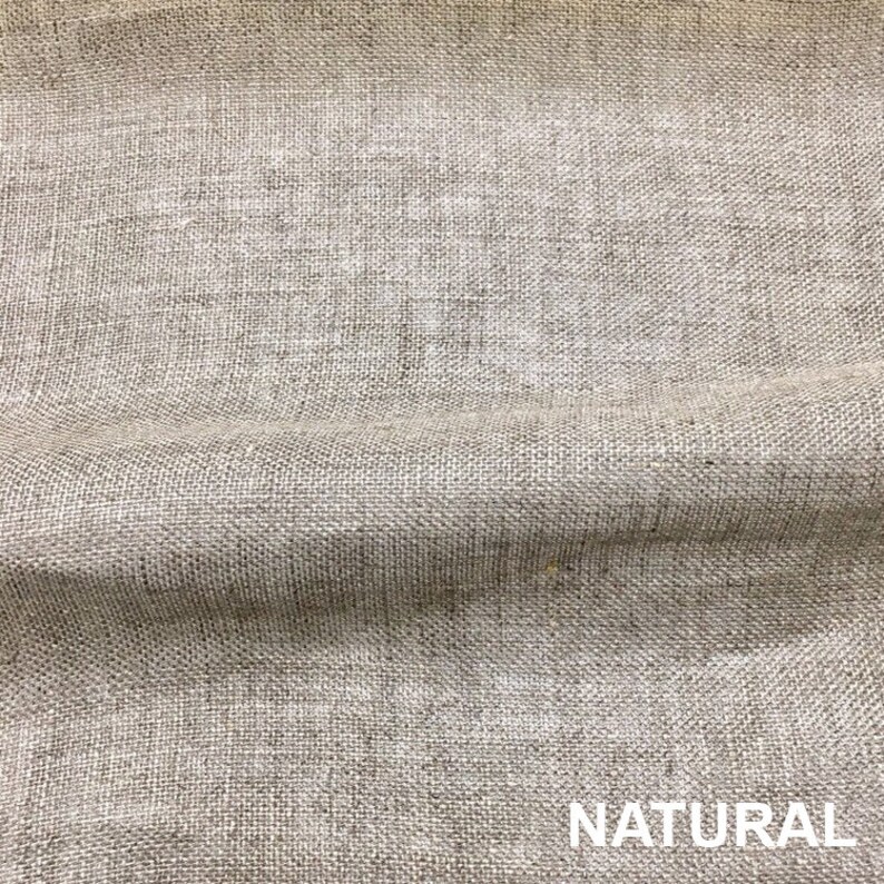 May include: Close-up of a natural-colored woven fabric with a textured surface. The fabric has a subtle sheen and a slightly rough feel. The word "NATURAL" is printed in white letters at the bottom of the image.