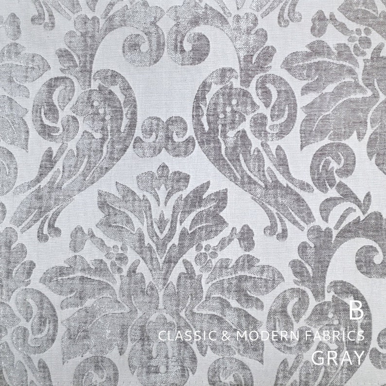 Puede incluir: Primer plano de una tela damasco plateada y blanca con un patr&oacute;n repetitivo de hojas y flores estilizadas. La tela es texturizada y tiene un brillo sutil. El texto "CLASSIC & MODERN FABRICS GRAY" est&aacute; impreso en la parte inferior de la imagen.