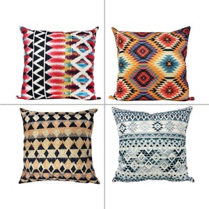 May include: Four square throw pillows with geometric patterns. One pillow features a black and white zigzag design, another has a colorful diamond pattern, a third has a black and tan diamond pattern, and the last has a blue and white geometric design.