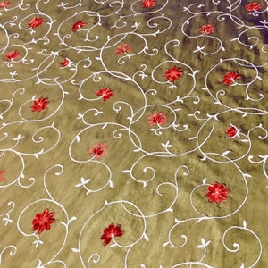May include: A brown fabric with a white floral pattern and red embroidered flowers.