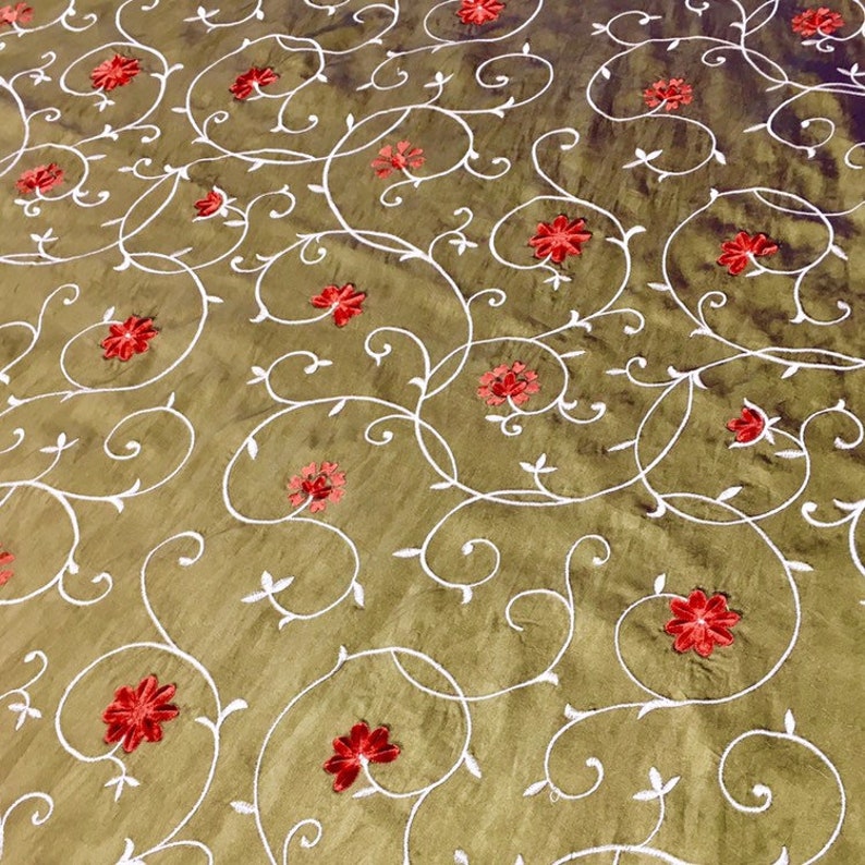 May include: A brown fabric with a white floral pattern and red embroidered flowers.
