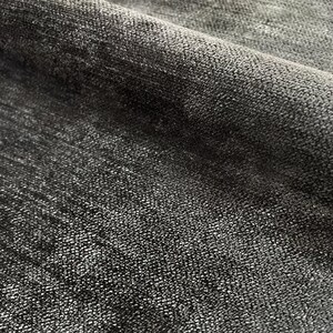 Puede incluir: Primer plano de una tela negra con una superficie texturizada. La tela tiene un brillo sutil y una sensaci&oacute;n ligeramente rugosa.