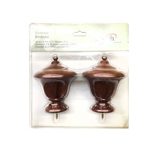 Könnte beinhalten: Ein Set mit zwei braunen Holz-Gardinenstangen-Endkappen. Die Endkappen haben einen Durchmesser von 3,8 cm und ein traditionelles Design.