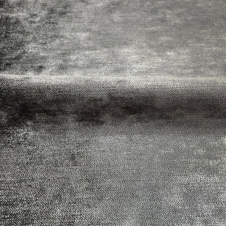 Puede incluir: Primer plano de una tela gris con un brillo sutil. La tela tiene una apariencia texturizada y tejida.