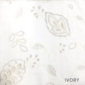 May include: White fabric with an embroidered floral pattern in shades of gray and beige. The fabric has the word "IVORY" printed in the bottom right corner.
