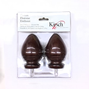 Puede incluir: Un juego de dos embellecedores de varilla para cortinas de color marrón. Los embellecedores tienen forma de lágrima y un diseño acanalado. El embalaje dice "Kirsch Elegance Defined" y "Set of 2 Fits 1 1/2" Diameter Pole".