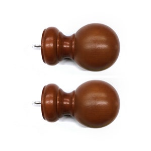 May include: Two brown wooden finials with a silver screw. The finials are round and have a smooth finish.