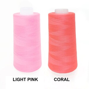 May include: Two spools of thread, one light pink and one coral.