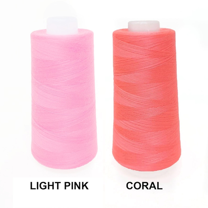May include: Two spools of thread, one light pink and one coral.