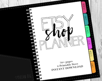 May include: A black and white planner with the text "ETSY shop PLANNER" in bold, outlined letters. The planner has a black cover with a silver spiral binding and a black pocket on the front. The text "DREAM BIG" is printed in white on the pocket. The planner has colourful tabs for different sections, including "Monthly", "Daily", "Business", "Social", "Website", and "Goals". The text "70+ pages", "8 Printable Sizes", and "INSTANT DOWNLOAD" is printed in black at the bottom of the page.
