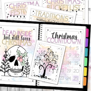 May include: A spiral-bound planner with several pages featuring Christmas-themed designs. The pages include text such as "Christmas Countdown," "Traditions," and "Dead Inside but still loves Christmas." The planner has a black cover and colorful tabs.