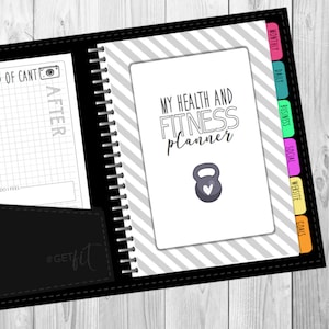 Può includere: Un'agenda in bianco e nero con una copertina a righe grigie e bianche. La copertina presenta il testo "My Health and Fitness Planner" e un manubrio grigio con un cuore bianco. L'agenda ha schede colorate per diverse categorie, tra cui "Mensile", "Giornaliero", "Business", "Social", "Sito web" e "Obiettivi".
