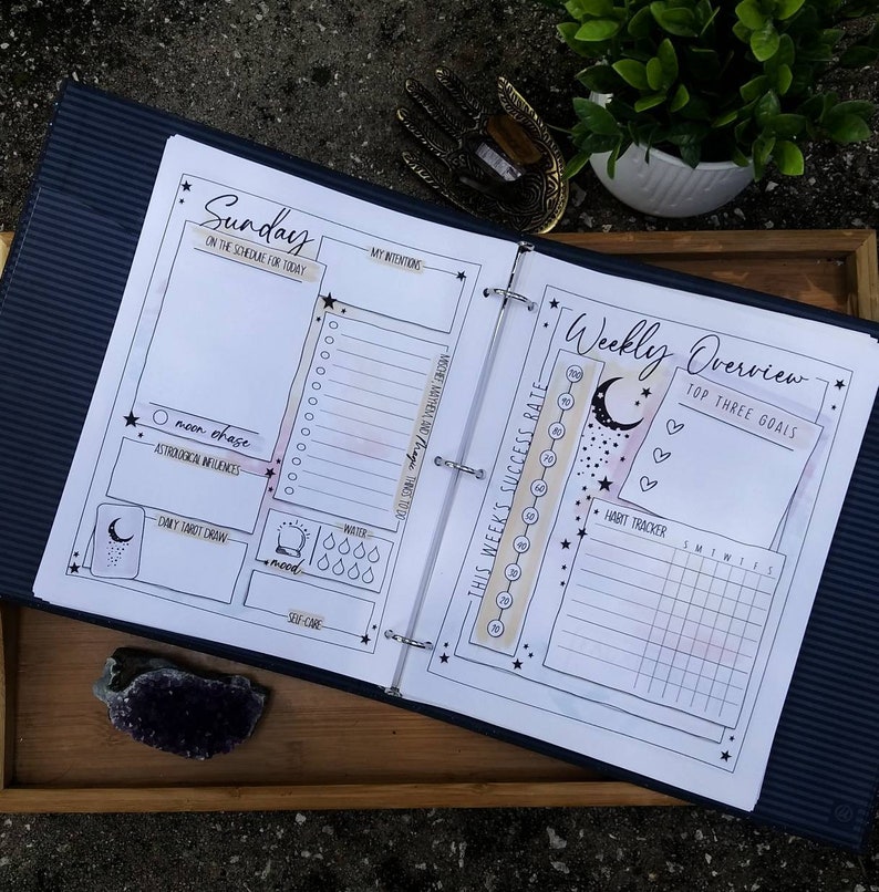 Puede incluir: Un planificador semanal con un dise&ntilde;o en blanco y negro que presenta una luna, estrellas y corazones. El planificador incluye secciones para tareas diarias, objetivos semanales, seguimiento de h&aacute;bitos y un rastreador de tasa de &eacute;xito.