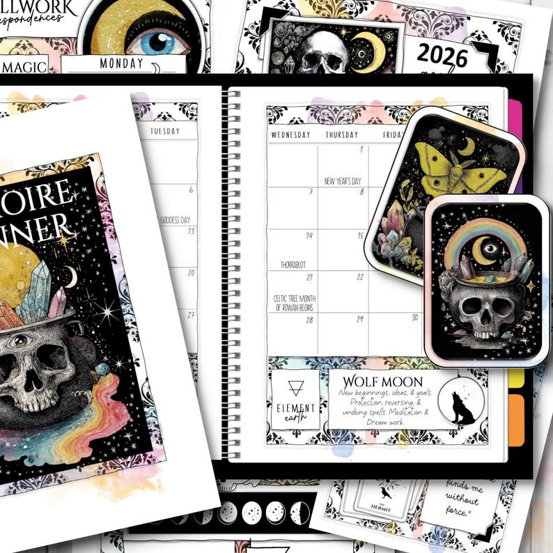May include: A planner with a black spiral binding, featuring a calendar, stickers, and decorative elements. The stickers include a skull, a moth, and a rainbow. The planner has the text "2026" and "Wolf Moon".