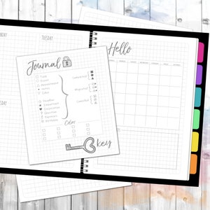 May include: A black and white planner with a grid pattern. The planner has a tabbed section with colorful tabs. The planner has a section for journaling with a key and a lock icon. The planner has a section for a weekly schedule with the days of the week listed. The planner has the word "Hello" written at the top.