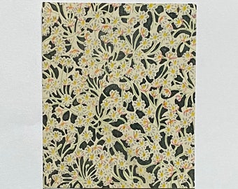 May include: A white mat with a framed print of a floral pattern. The pattern features white flowers with yellow centers and pink accents on a dark green background.