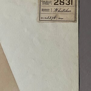 May include: A white paper document with a brown label. The label has the text "Class No. of the School or Class." and "Student's Surname." The label also has the numbers "2831" and "1370" and the name "Whitcher" written in cursive.