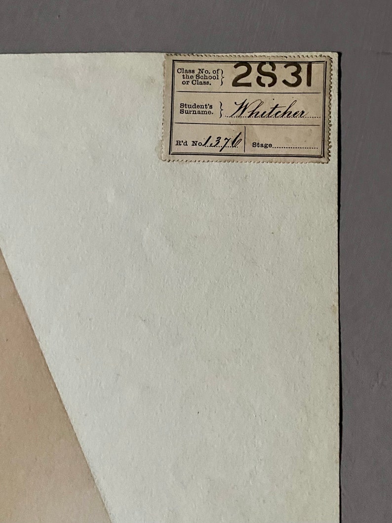 May include: A white paper document with a brown label. The label has the text "Class No. of the School or Class." and "Student's Surname." The label also has the numbers "2831" and "1370" and the name "Whitcher" written in cursive.