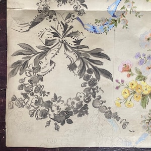 May include: A close-up of a vintage wallpaper design featuring a black and white floral pattern with a large bow and a blue ribbon. The design is on a cream-colored background.