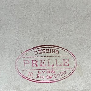 May include: A red oval stamp with the text "DESSINS PRELLE LYON 10, Rue du Griffon" in white.