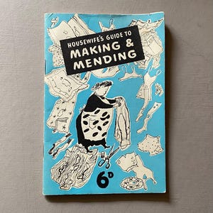 May include: A vintage book cover titled "Housewife's Guide to Making & Mending" on a light blue background. The cover features a black and white illustration of a woman and various sewing-related items. The price is indicated as 6d.