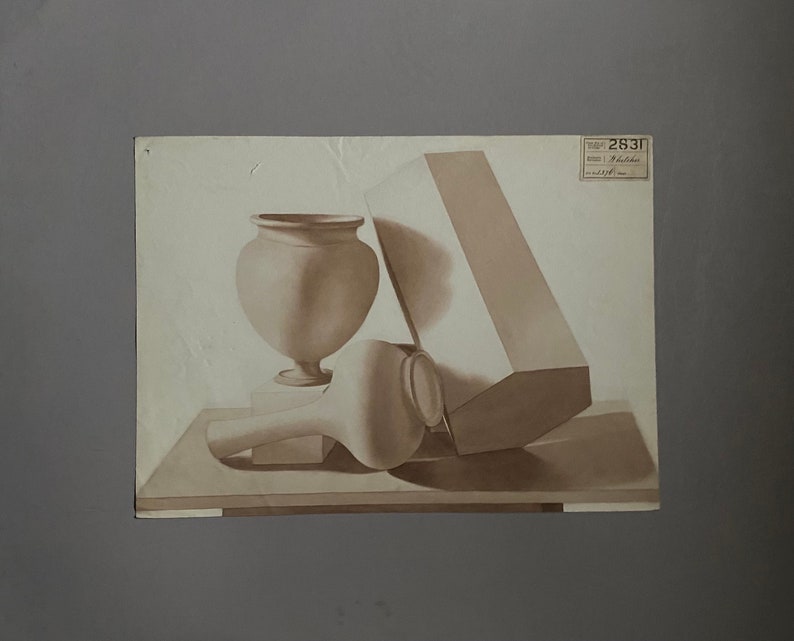 May include: A still life drawing of a vase, a round object, and a rectangular box on a table. The drawing is in shades of brown.