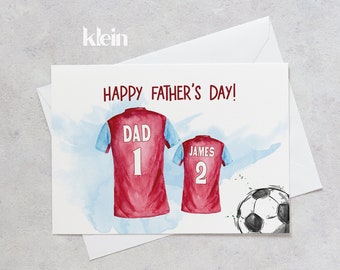 Op de afbeelding: Gelukkige Vaderdag kaart met een aquarel illustratie van twee voetbalshirts. Het shirt aan de linkerkant zegt "Dad 1" en het shirt aan de rechterkant zegt "James 2". Een voetbal bevindt zich in de rechterbenedenhoek.
