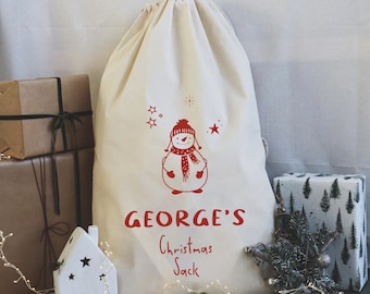 May include: A white canvas Christmas sack with a red snowman design and the text "GEORGE'S Christmas Sack".