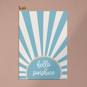 May include: A blue and white striped sunburst design with a peach colored circle in the center. The circle has the text "hello sunshine" in white.