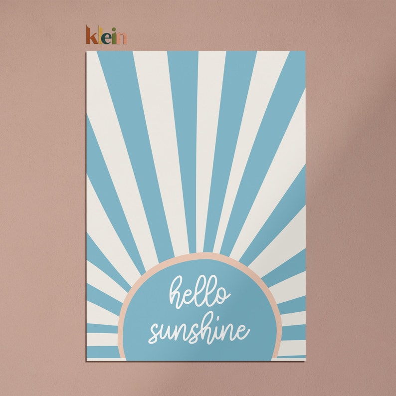 May include: A blue and white striped sunburst design with a peach colored circle in the center. The circle has the text "hello sunshine" in white.