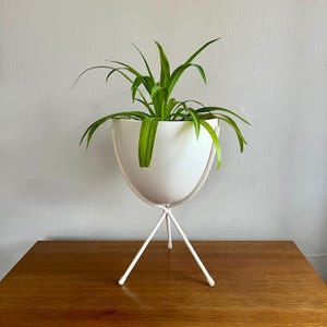 Puede incluir: Un juego de tres tazas de cerámica con un acabado mate moteado. Las tazas son en tonos crema, gris claro y gris oscuro. Cada taza tiene un diseño simple y moderno y un asa redondeada.