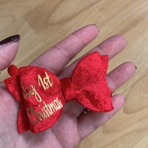 May include: Red velvet bow with a gold inscription that reads "My 1st Christmas".