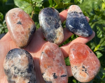 May include: Six tumbled stones, some with pink and white patterns, others with blue and white patterns. The stones are smooth and polished.