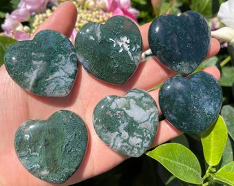 May include: Seven green moss agate heart shaped stones. The stones have a swirling pattern of green and white.