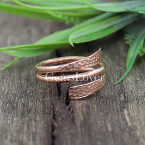 Pode incluir: Um anel de cobre martelado com um design torcido. O anel &eacute; feito de duas bandas de cobre que s&atilde;o torcidas juntas. O cobre tem uma cor quente marrom avermelhada.