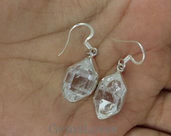 Puede incluir: Un par de pendientes de plata con cristales de cuarzo transparentes. Los cristales son facetados y tienen una forma geométrica. Los pendientes son de estilo colgante y tienen un cierre de gancho.