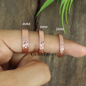 May include: Three copper rings of different widths, 4mm, 3mm, and 2mm, are shown on a finger. The rings are hammered with a textured surface.