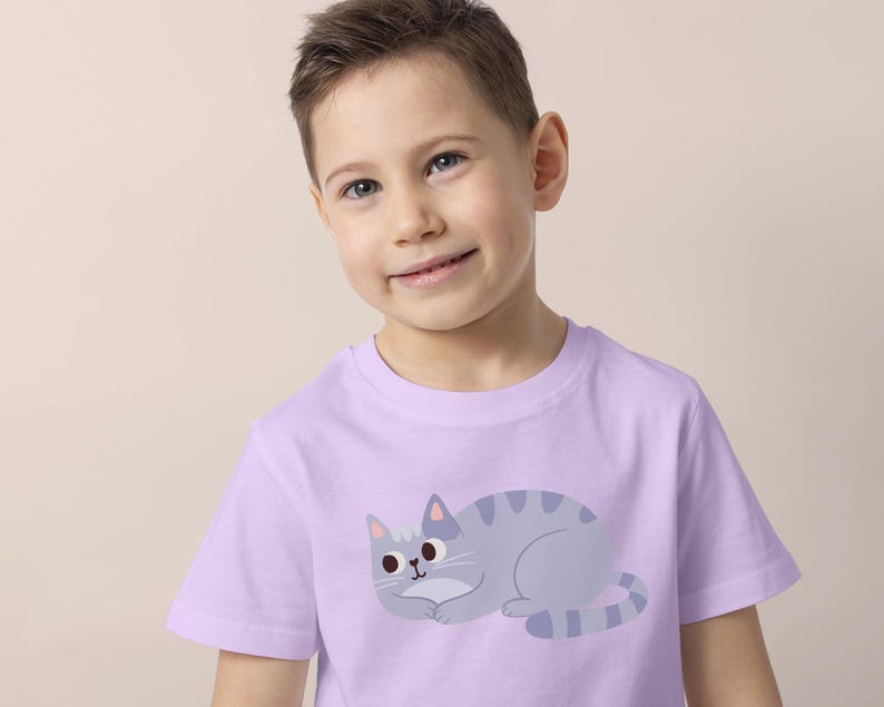 Pode incluir: Uma camiseta lil&aacute;s clara com uma ilustra&ccedil;&atilde;o de gato de desenho animado. O gato &eacute; cinza com listras cinza mais escuras e um nariz rosa. A camiseta &eacute; de manga curta e parece ser feita de um material macio.