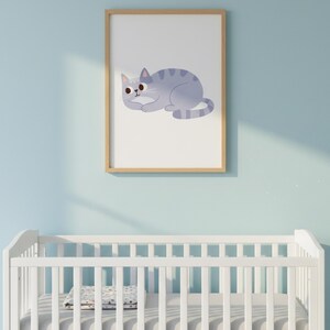 Pode incluir: Uma impress&atilde;o emoldurada com uma ilustra&ccedil;&atilde;o de gato azul claro com listras azuis escuras. O gato est&aacute; deitado. A obra de arte &eacute; exibida acima de um ber&ccedil;o branco contra uma parede azul clara.