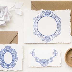 Puede incluir: Juego de papeler&iacute;a con marcos azules ornamentados sobre tarjetas blancas texturizadas. Los dise&ntilde;os incluyen marcos redondos, ovalados y semicirculares. Sobres marrones, un cuenco de madera con anillos y una flor de papel completan el conjunto. Medidas m&eacute;tricas no aplicables.