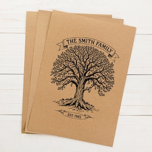 Pu&ograve; includere: Un mazzo di carte di carta marrone con un'illustrazione in bianco e nero di un albero con il testo "The Smith Family Est. 1985".
