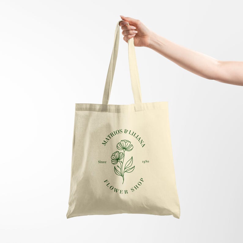 May include: A beige tote bag with a green floral design and the text "Matrios & Lilliana Flower Shop Since 1980" printed on the front.