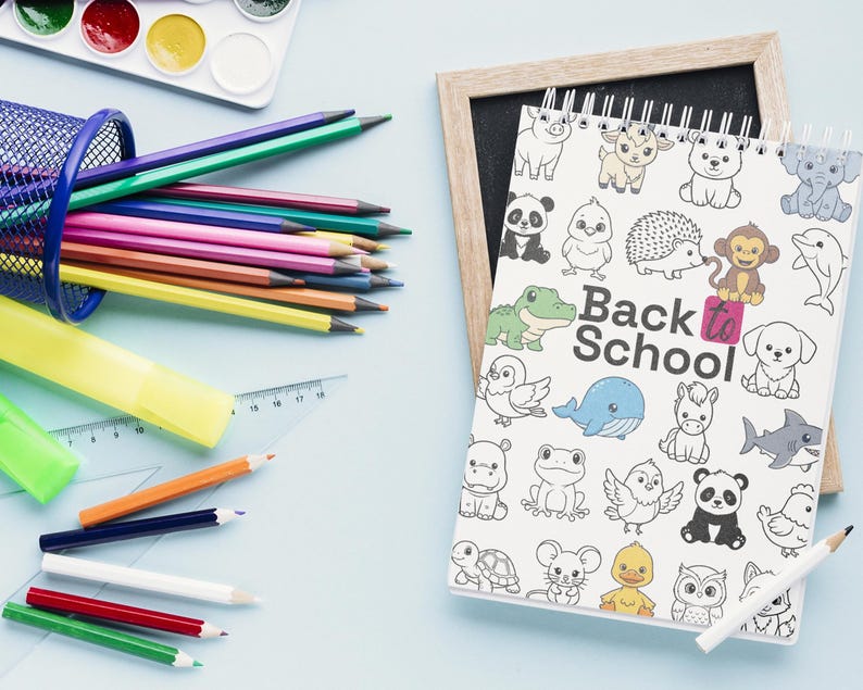 May include: A collection of school supplies on a light blue surface. Includes a wire mesh pencil holder filled with colored pencils, a watercolor paint set, a notebook with animal illustrations and the text "Back to School", and a ruler.