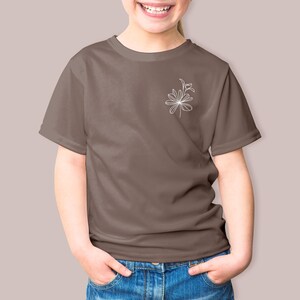 May include: A brown t-shirt with a white line drawing of a flower on the left chest.