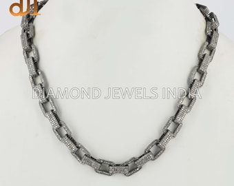 May include: A silver-toned chain necklace with rectangular links, each encrusted with small, sparkling stones. The necklace is displayed on a white surface, with the text "DIAMOND JEWELS INDIA" visible.
